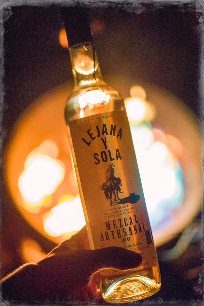 Lejana y Sola Mezcal Artesanal bottle with dramatic blue bokeh background